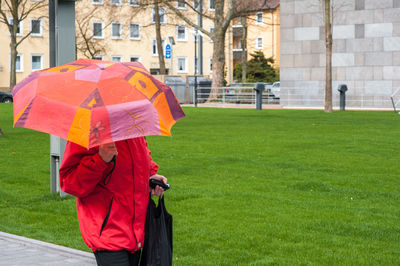 Rear view of man with umbrella walking in rain