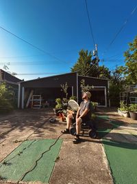 Rear view of woman sitting on grass