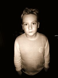 Portrait of boy against black background