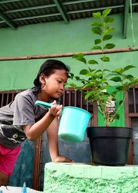 Happy girl holding potted plant