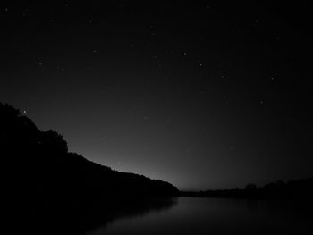 Scenic view of lake against sky at night