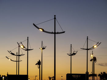 Low angle view of illuminated street light against sky at sunset