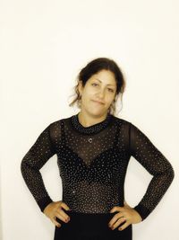 Portrait of young woman standing against white background