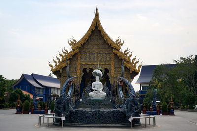 Statue against temple building against sky