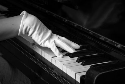 Close-up of human hand wearing glove playing piano