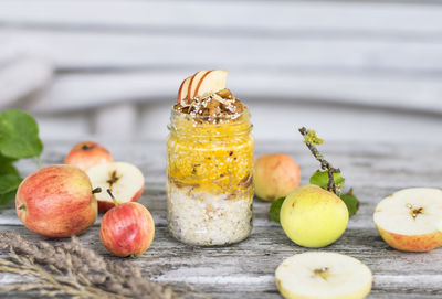 Food in jar amidst apples on table