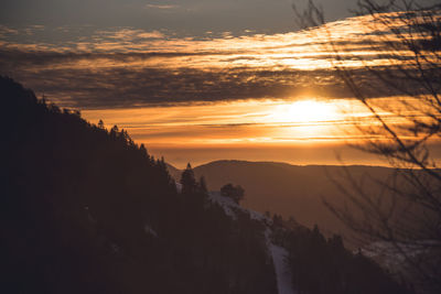 Scenic view of silhouette mountains against orange sky