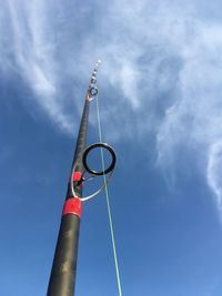 Low angle view of surfcasting rod against sky