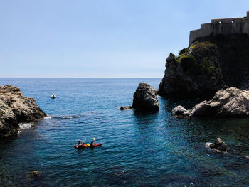 Scenic view of rocks in sea against clear sky