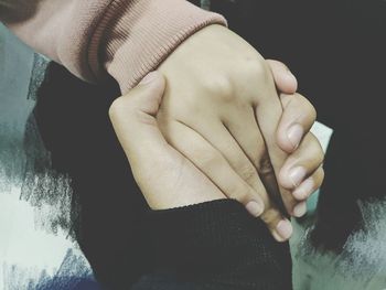 Cropped image of couple holding hands