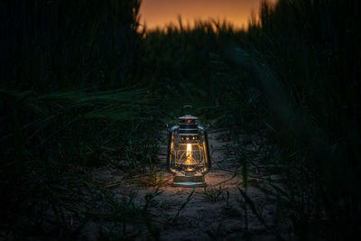 Illuminated lantern on field at night