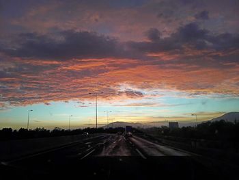 Road passing through dramatic sky at sunset