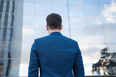 Rear view of businessman standing against modern building