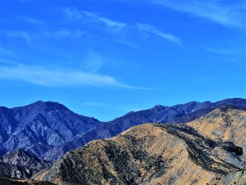 Scenic view of mountains against blue sky