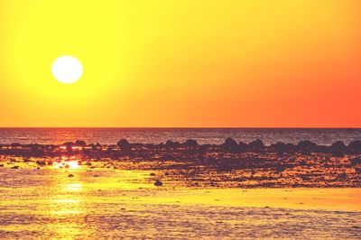 Scenic view of sea against orange sky