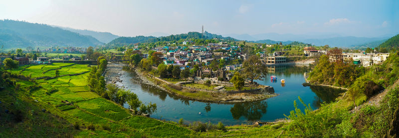 High angle view of townscape by lake against sky