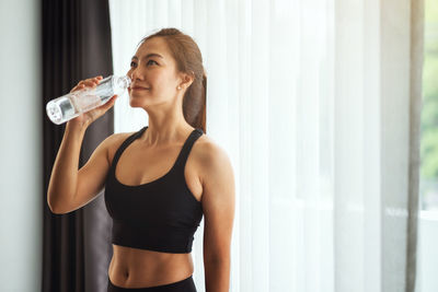 Young woman drinking water from bottle