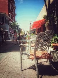 Chairs in market against sky in city