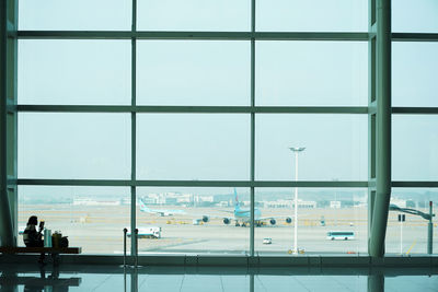 Airport runway seen through glass window