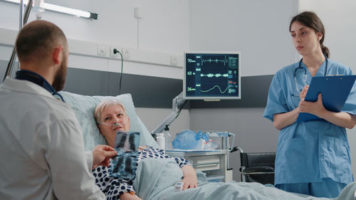 Nurse and doctor examining patient in clinic