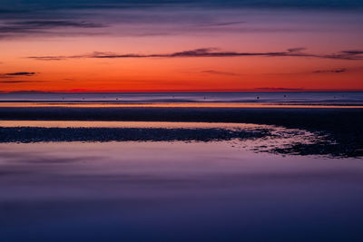 Scenic view of sea against romantic sky at sunset