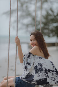 Woman sitting on swing at playground