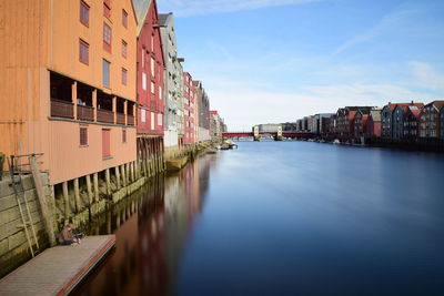 Canal amidst buildings in city against sky