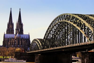 Low angle view of hohenzollern bridge by cologne cathedral against sky
