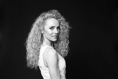 Portrait of a beautiful young woman over black background