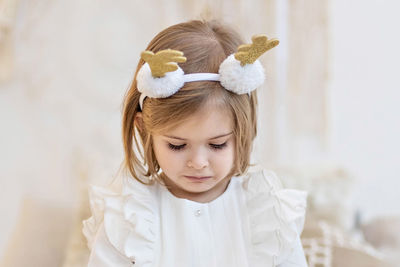 Portrait of young toddler girl looking away while  against wall