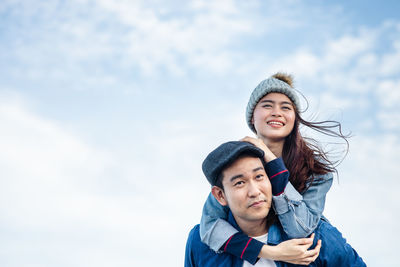 Portrait of a smiling young woman against sky during winter