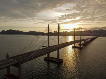 Pier over sea against sky during sunset