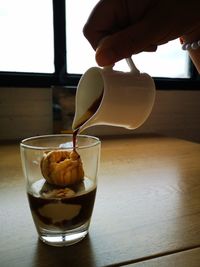 Close-up of hand pouring drink in glass