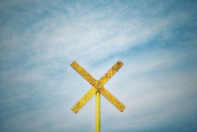 Low angle view of yellow flag against sky