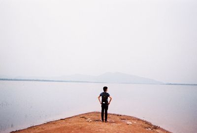 Rear view of man looking at sea against sky