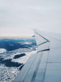 Airplane flying over landscape against sky