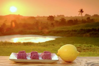 Close-up of fruits on table during sunset