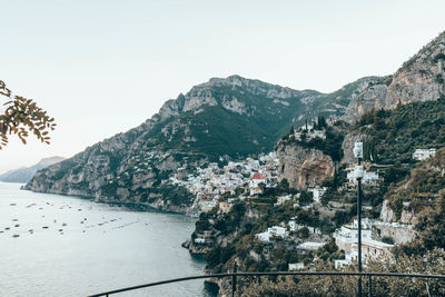 Scenic view of sea and buildings against clear sky