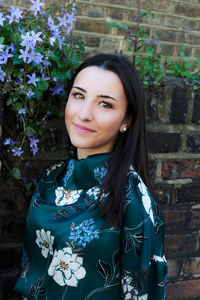 Portrait of smiling young woman against white wall