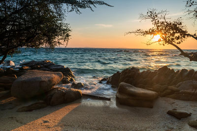 Motion wave seascape through stone arch at sunrise in ko man klang, rayong, thailand or siam.