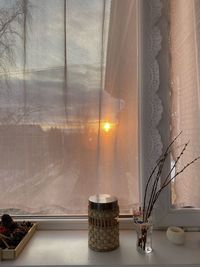 Illuminated electric lamp on table by window at home