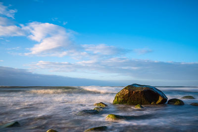 Rocks on sea shore against sky