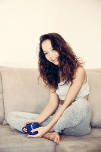 Beautiful young woman sitting at home