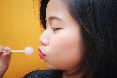 Profile view of woman eating lollipop