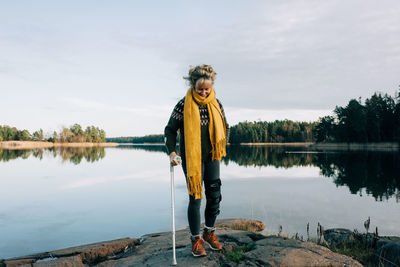 Man standing by lake against sky