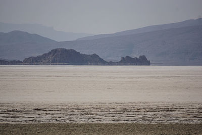 Scenic view of sea and mountains against sky