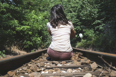 Rear view of woman on railroad track