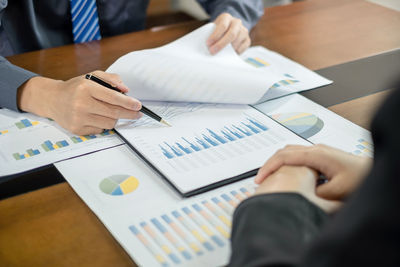 Midsection of business colleagues working on table