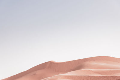 Sand dunes against clear sky