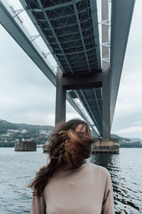 Woman standing under bridge